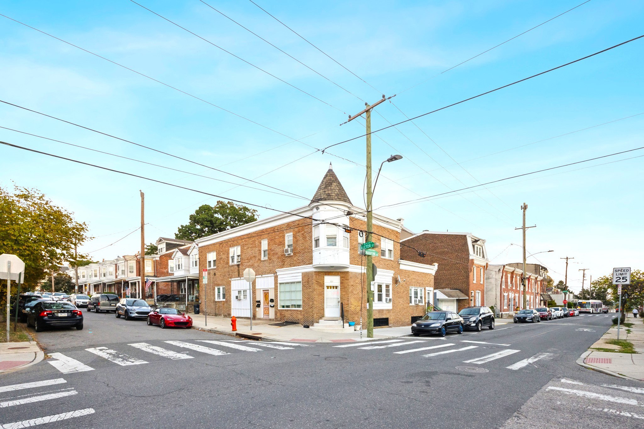 A street view with cars, buildings, and a pedestrian crossing.